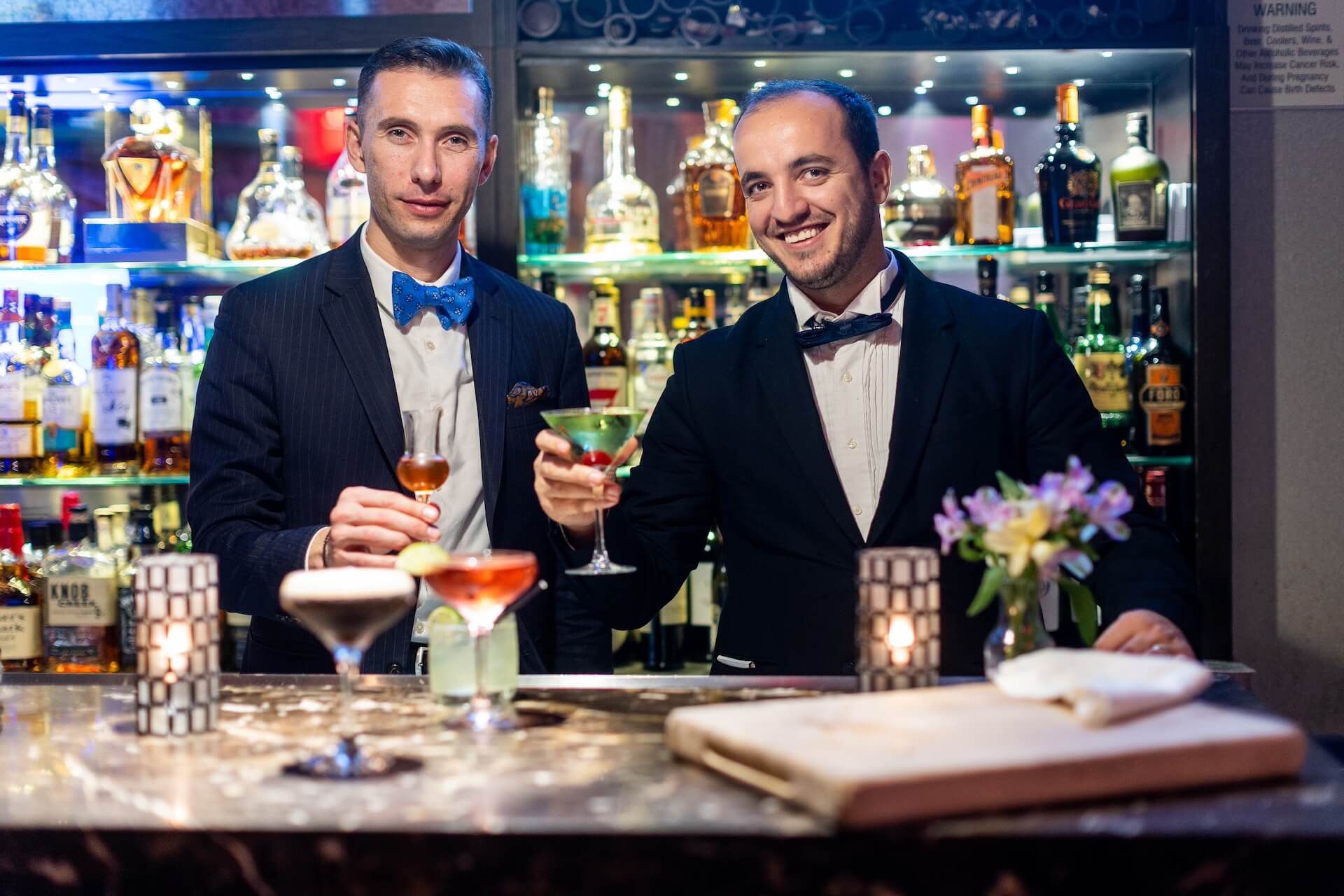 2 cater waiters serving drinks at the bar